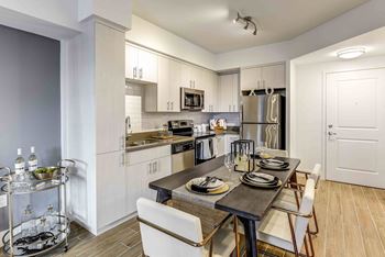 A modern kitchen with a dining table set for two.